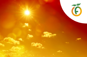 Bright sun with lens flare in a warm orange-yellow sky, scattered clouds, and a white curved banner in the top-right featuring a green-orange logo.